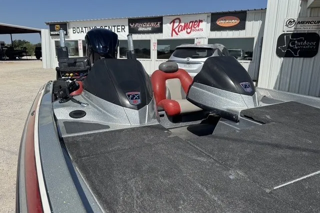 Slide: The Image of 2013 Skeeter FX21 boat at dealership, featuring dual consoles and red seating. - 10
