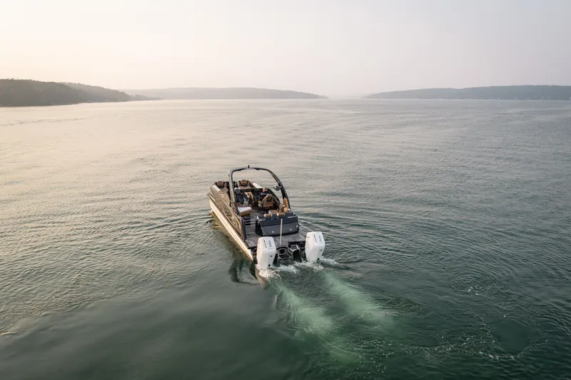 Slide: The Image of 2026 Tahoe Pontoon Grand Tahoe LTD Cruise Rear Bench on serene lake waters. - 20