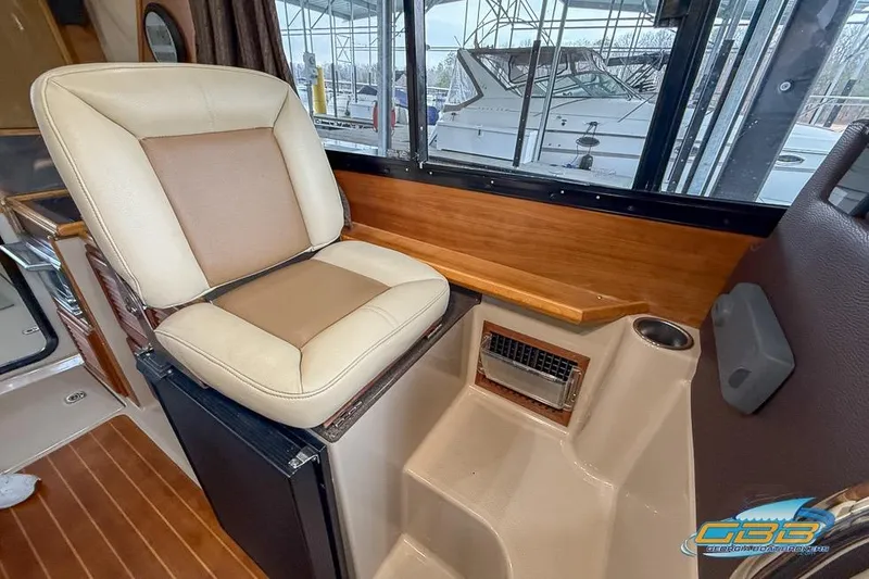 Slide: The Image of Interior of a 2013 Cutwater C-28 boat featuring a cushioned seat and wooden accents. - 42