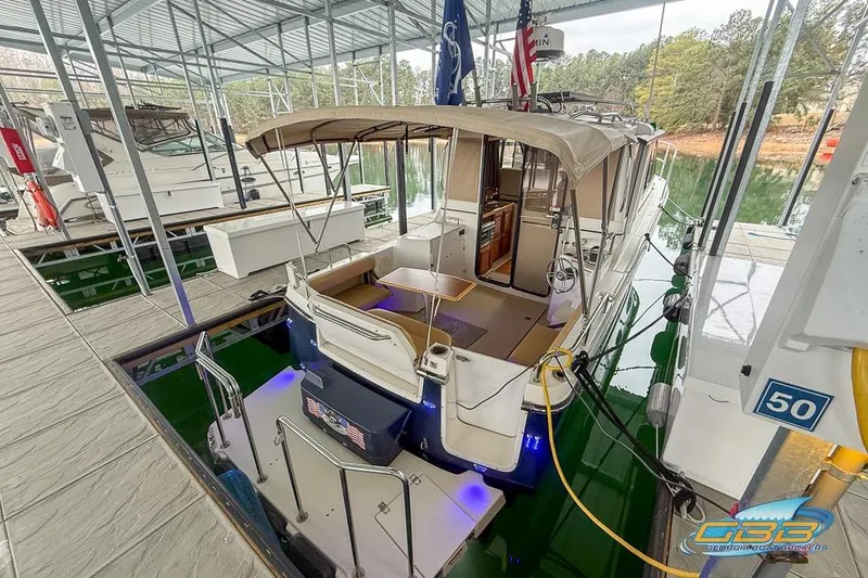 Slide: The Image of 2013 Cutwater C-28 boat docked in a marina with canopy and flags. - 19