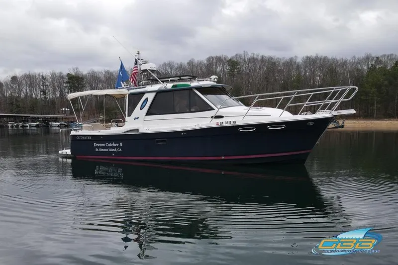 Slide: The Image of 2013 Cutwater C-28 boat, "Dream Catcher II," on calm water near wooded shoreline. - 18