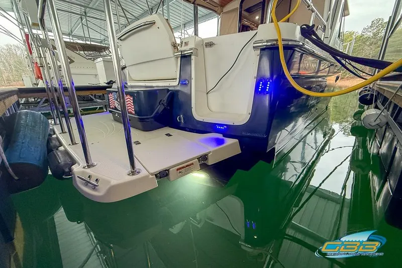 Slide: The Image of 2013 Cutwater C-28 boat docked, featuring swim platform and blue LED lights. - 79