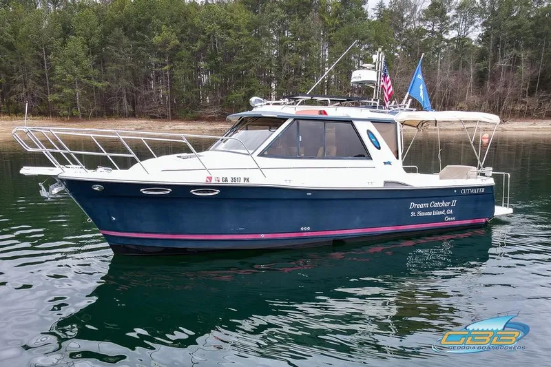 The Image of 2013 Cutwater C-28 boat on calm water, forested shoreline in background. - 0