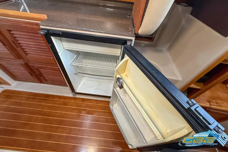 Slide: The Image of 2013 Cutwater C-28 interior with open refrigerator, wooden flooring, and countertop. - 54