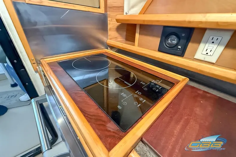 Slide: The Image of 2013 Cutwater C-28 boat kitchen with electric stove and wooden cabinetry. - 33