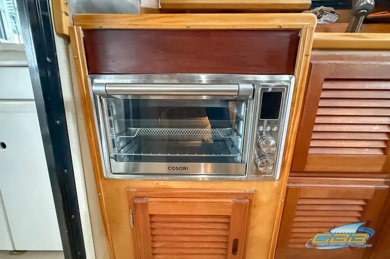 Slide: The Image of 2013 Cutwater C-28 interior with a built-in Cosori oven in wooden cabinetry. - 34