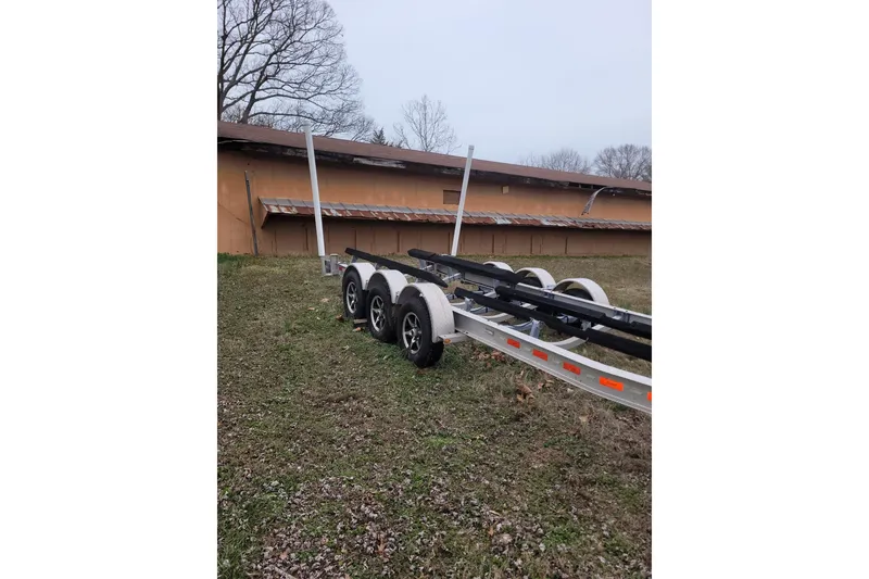 Slide: The Image of Trailer for 2013 Cutwater C-28 boat parked on grassy area near building. - 85