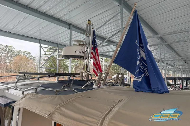 Slide: The Image of 2013 Cutwater C-28 boat with flags, docked under a metal canopy. - 72