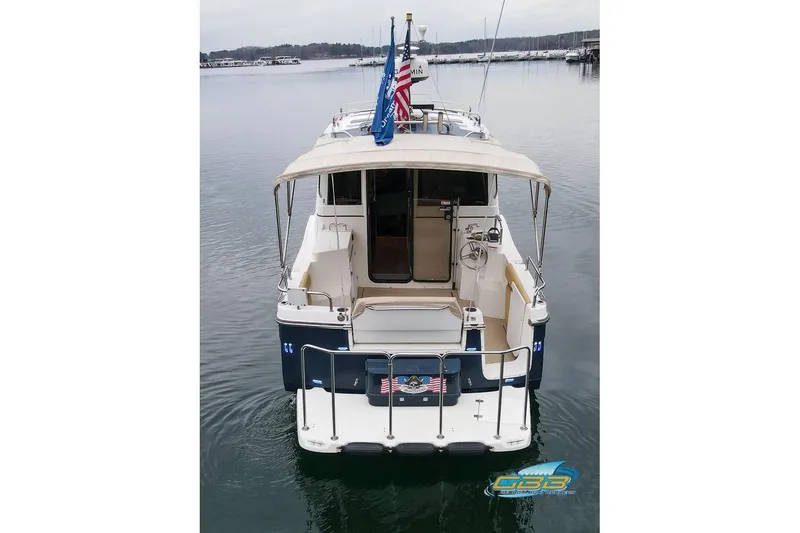 Slide: The Image of 2013 Cutwater C-28 boat docked, rear view with flags and calm water. - 14