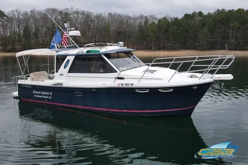Slide: The Image of 2013 Cutwater C-28 boat "Dream Catcher II" on calm water near forested shoreline. - 13