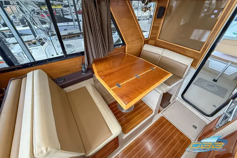 Slide: The Image of Interior of 2013 Cutwater C-28 boat with wooden table and beige seating. - 28