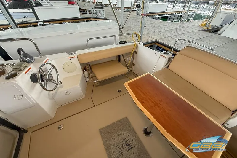 Slide: The Image of 2013 Cutwater C-28 boat interior with helm, seating, and wooden table. - 60