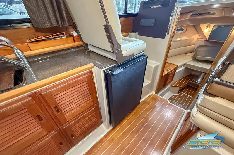 Slide: The Image of Interior of 2013 Cutwater C-28 boat with wood finishes and compact kitchen area. - 26