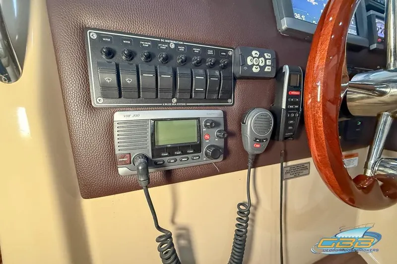 Slide: The Image of Control panel of a 2013 Cutwater C-28 boat with VHF radio and switches. - 53