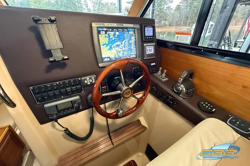 Slide: The Image of 2013 Cutwater C-28 helm with navigation display, wooden steering wheel, and control panel. - 30