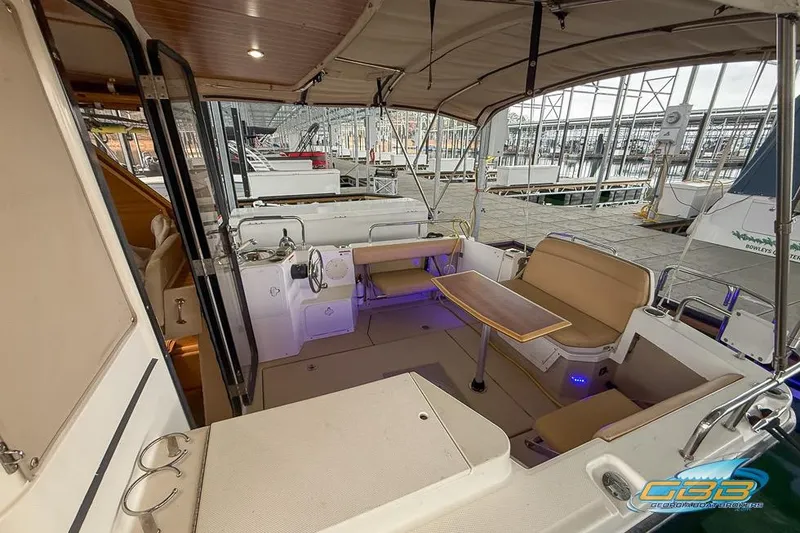 Slide: The Image of 2013 Cutwater C-28 boat interior with seating and table, docked at a marina. - 73