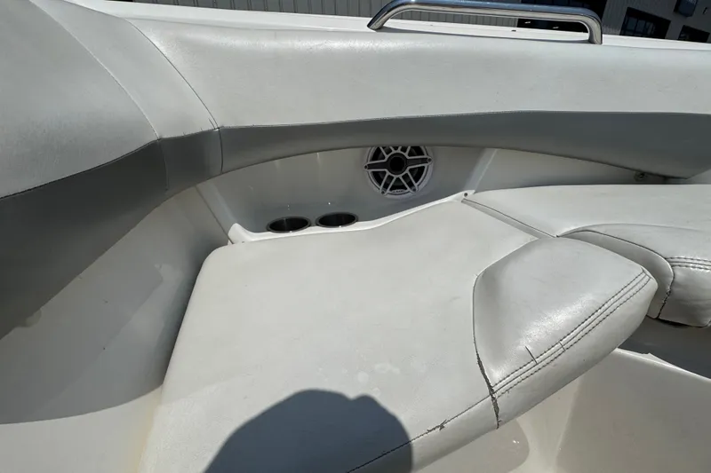 Slide: The Image of 2008 Larson LXi 228 boat interior with white seating and speaker detail. - 16