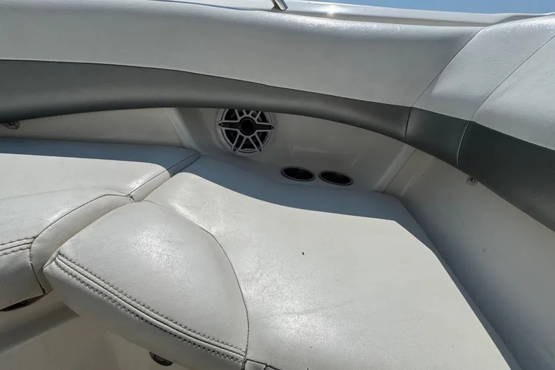 Slide: The Image of 2008 Larson LXi 228 boat interior with white seating and speaker detail. - 17