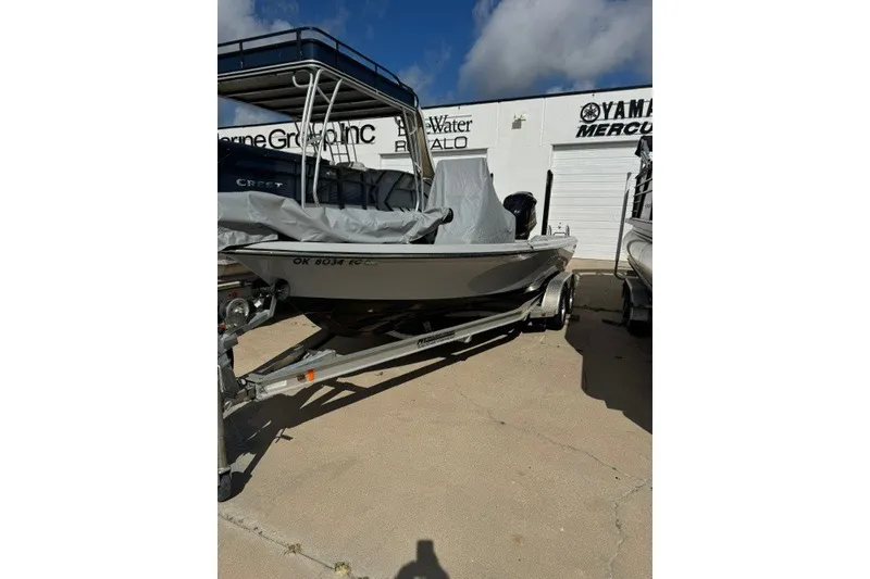 Slide: The Image of 2015 BLUEWAVE 2200 PURE boat on trailer, covered, parked outside dealership. - 14