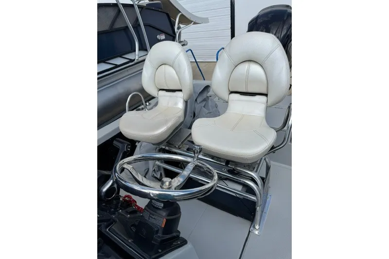 Slide: The Image of Dual white captain seats on a 2015 BLUEWAVE 2200 PURE boat. - 2