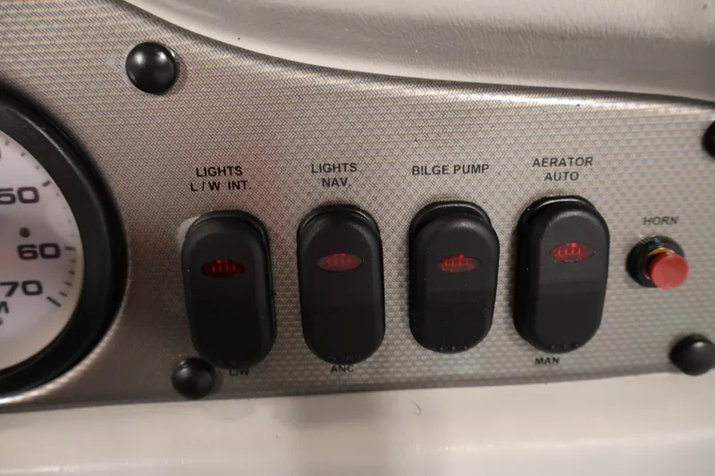 Slide: The Image of Dashboard controls of a 2004 Alumacraft Navigator 165 CS boat, featuring switches and gauges. - 26