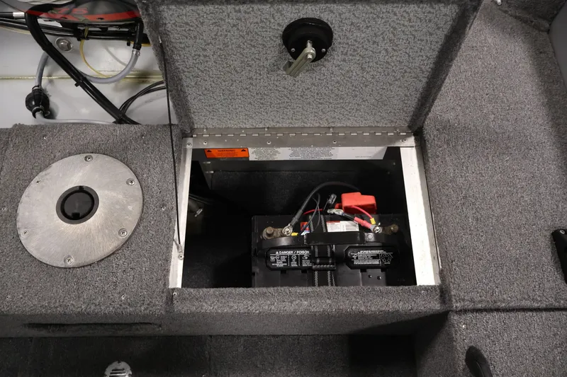 Slide: The Image of 2004 Alumacraft Navigator 165 CS boat battery compartment with wiring and carpeted interior. - 36