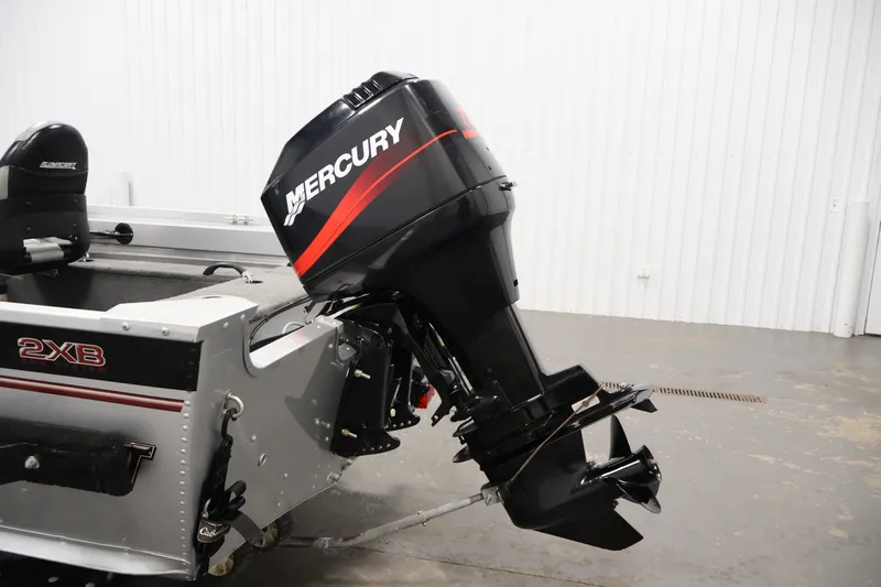 Slide: The Image of 2004 Alumacraft Navigator 165 CS boat with Mercury outboard motor in a garage setting. - 39
