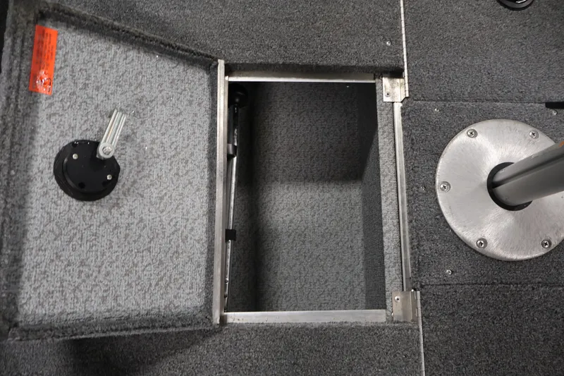 Slide: The Image of 2004 Alumacraft Navigator 165 CS boat interior storage compartment with gray carpet. - 16