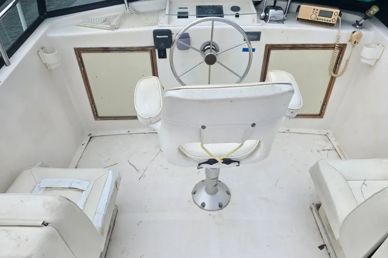 Slide: The Image of Cockpit of 1983 Atlantic 30 LRC boat with steering wheel and white seating. - 8