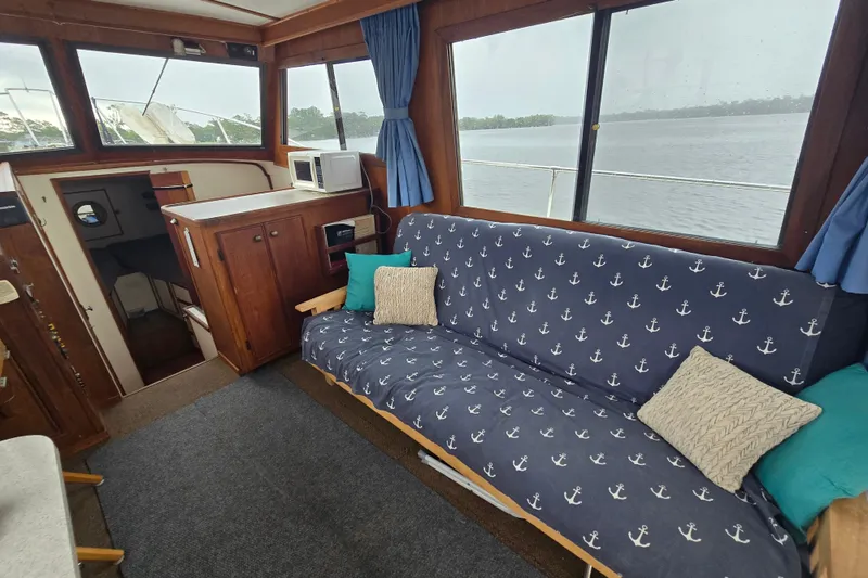 Slide: The Image of Cozy interior of 1983 Atlantic 30 LRC boat with anchor-patterned sofa and scenic window view. - 10