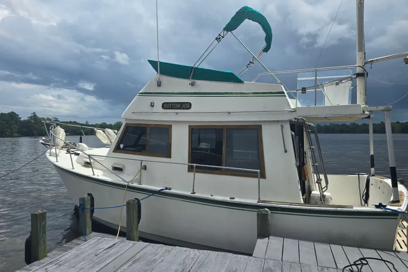 Slide: The Image of 1983 Atlantic 30 LRC boat docked by a lake under cloudy skies. - 3