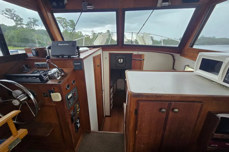 Slide: The Image of Interior of 1983 Atlantic 30 LRC boat with helm, controls, and kitchenette. - 12