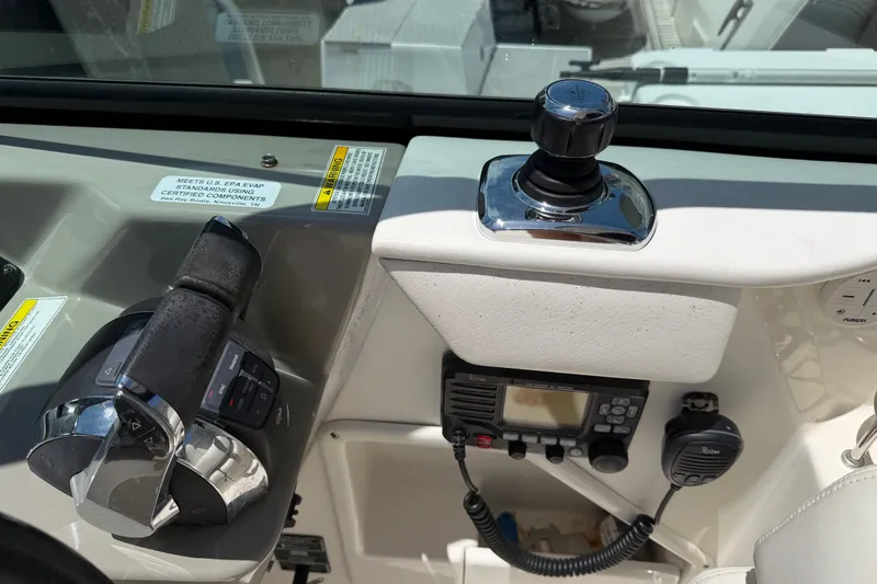 Slide: The Image of Control panel of a 2015 Sea Ray 370 Venture boat with throttle and communication equipment. - 31