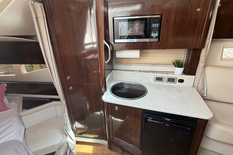 Slide: The Image of Interior of 2015 Sea Ray 370 Venture yacht with kitchenette, microwave, and seating area. - 42
