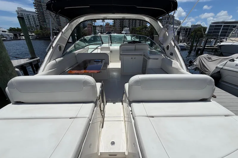 Slide: The Image of 2015 Sea Ray 370 Venture yacht interior with white seating and dockside view. - 17