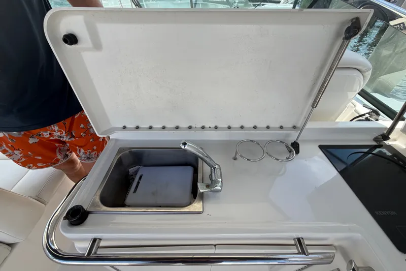 Slide: The Image of 2015 Sea Ray 370 Venture boat sink with cutting board and cup holders. - 23