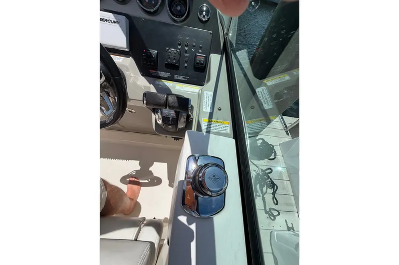 Slide: The Image of 2015 Sea Ray 370 Venture helm with controls and steering wheel in sunlight. - 38