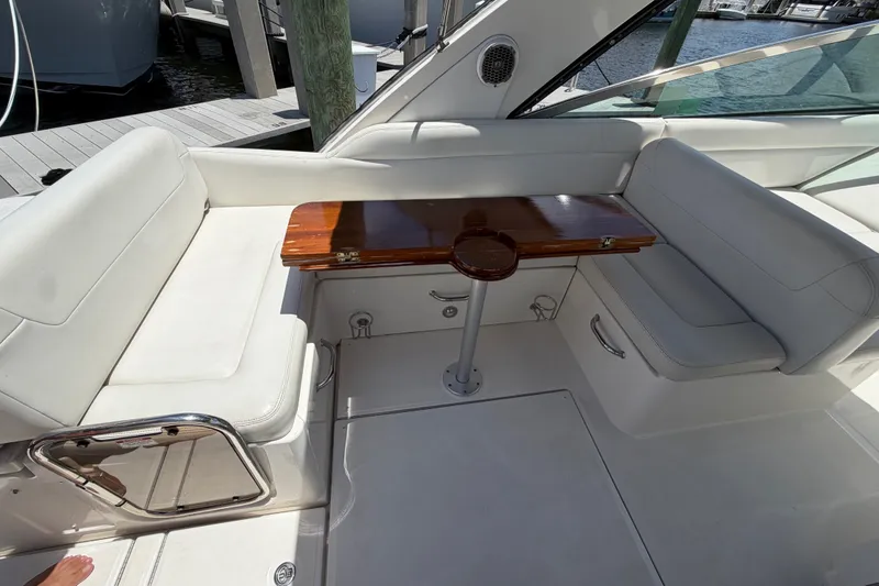 Slide: The Image of 2015 Sea Ray 370 Venture boat interior with white seating and wooden table. - 15