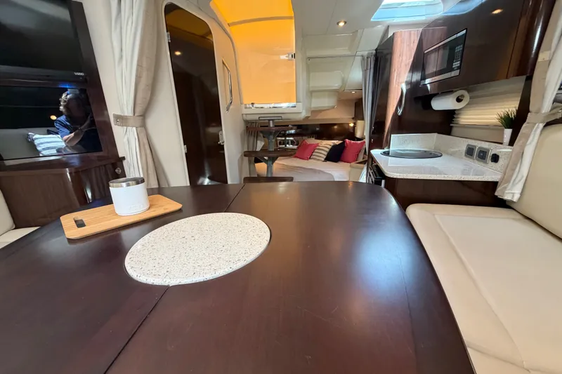 Slide: The Image of Interior of 2015 Sea Ray 370 Venture yacht, featuring dining area and cozy seating. - 50