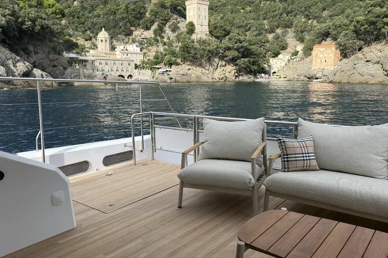 Slide: The Image of Aventura 56 Motor Yacht 2026 deck with scenic coastal view and comfortable seating. - 12