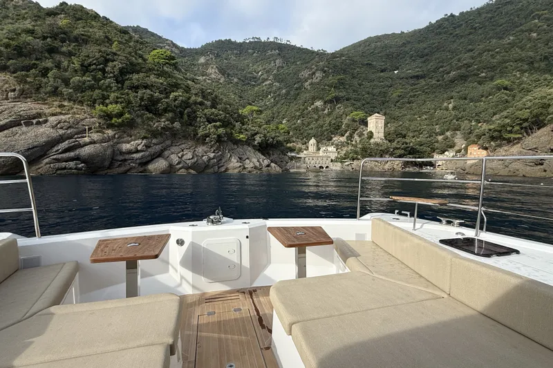 Slide: The Image of Aventura 56 Motor Yacht 2026 cruising near scenic coastal cliffs and historic buildings. - 10
