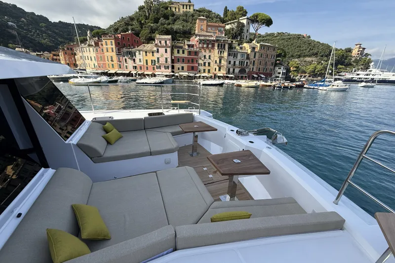 Slide: The Image of Luxurious 2026 Aventura 56 Motor Yacht docked in scenic harbor with colorful buildings. - 33