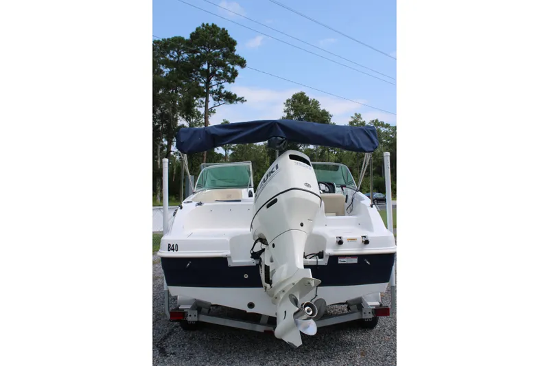 Slide: The Image of 2020 Hurricane SunDeck 187 OB boat with outboard motor, parked on gravel. - 21