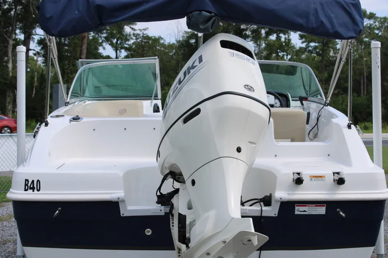 Slide: The Image of 2020 Hurricane SunDeck 187 OB boat with Suzuki outboard motor, parked outdoors. - 22