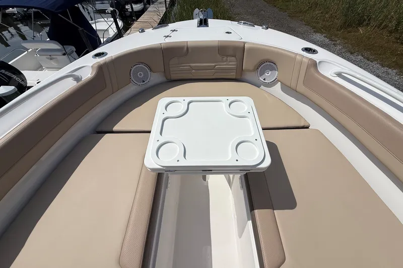 Slide: The Image of 2025 Edgewater 248CX Crossover boat interior with cushioned seating and table. - 28