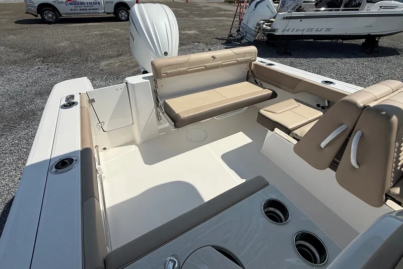 Slide: The Image of 2025 Edgewater 248CX Crossover boat interior with beige seating and cup holders. - 10