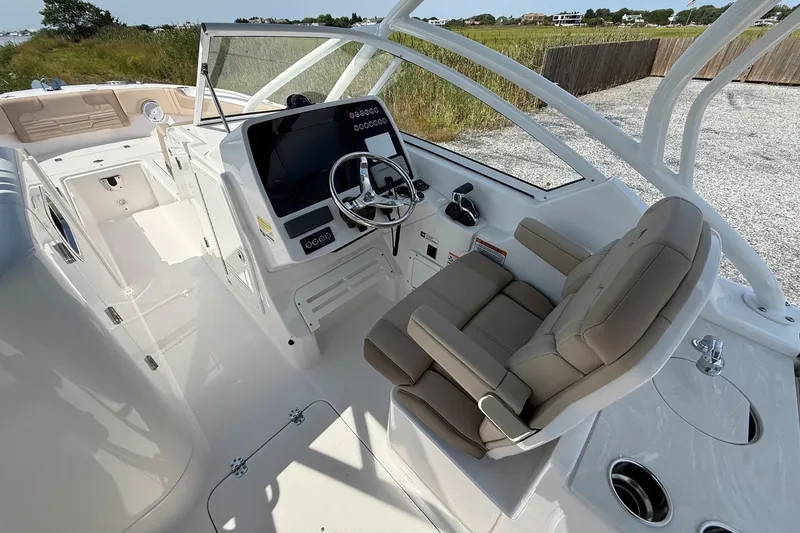 Slide: The Image of 2025 Edgewater 248CX Crossover boat interior with modern helm and comfortable seating. - 16
