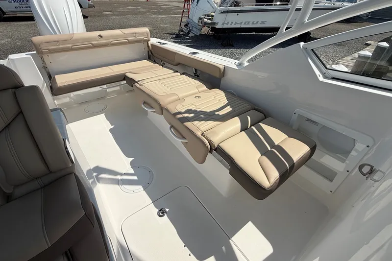 Slide: The Image of 2025 Edgewater 248CX Crossover boat interior with beige seating and spacious layout. - 11
