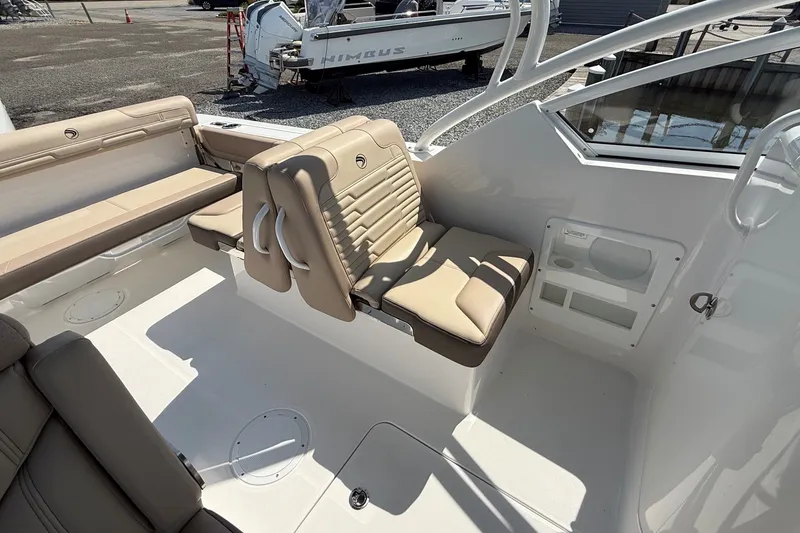 Slide: The Image of 2025 Edgewater 248CX Crossover boat interior with beige seating and modern design. - 15