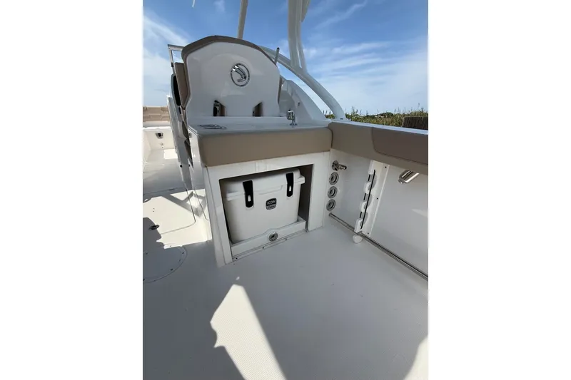 Slide: The Image of 2025 Edgewater 248CX Crossover boat interior with seating and storage compartment. - 18